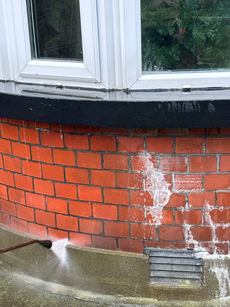 Brick chemical cleaning in progress under a bay window in Dublin